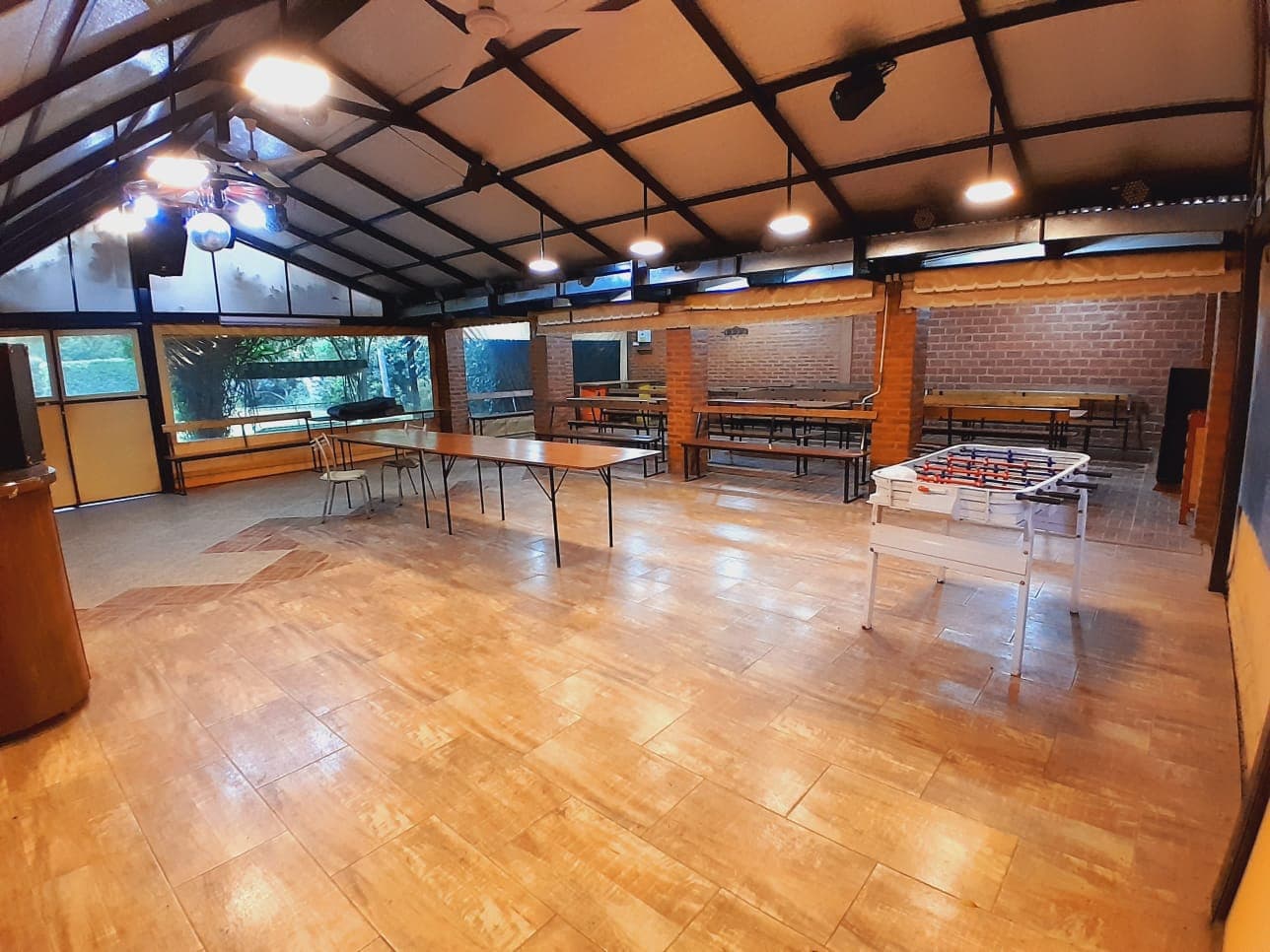 Salón con mesa y bancos y metegol