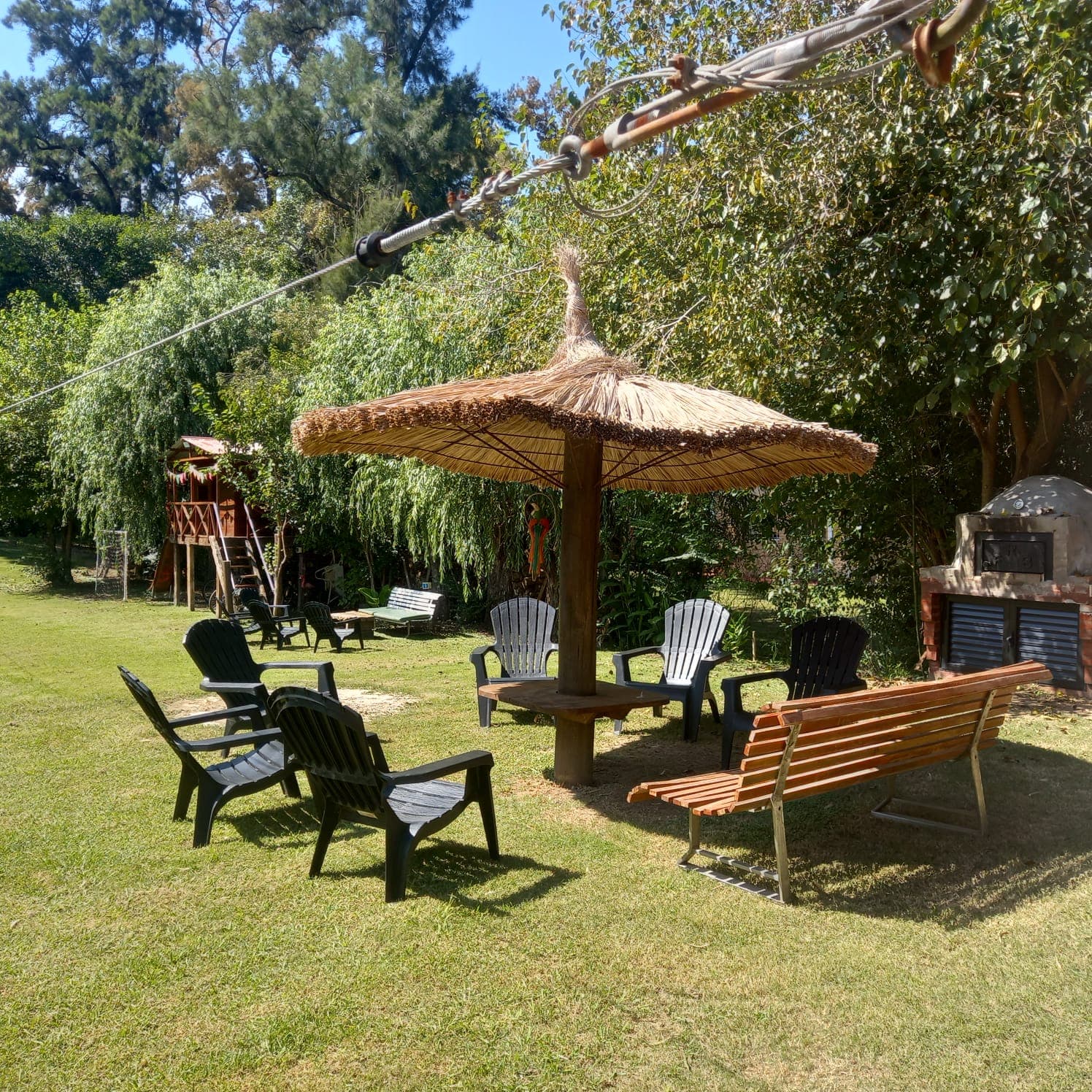Sombrilla de paja con bancos en quinta en alquiler