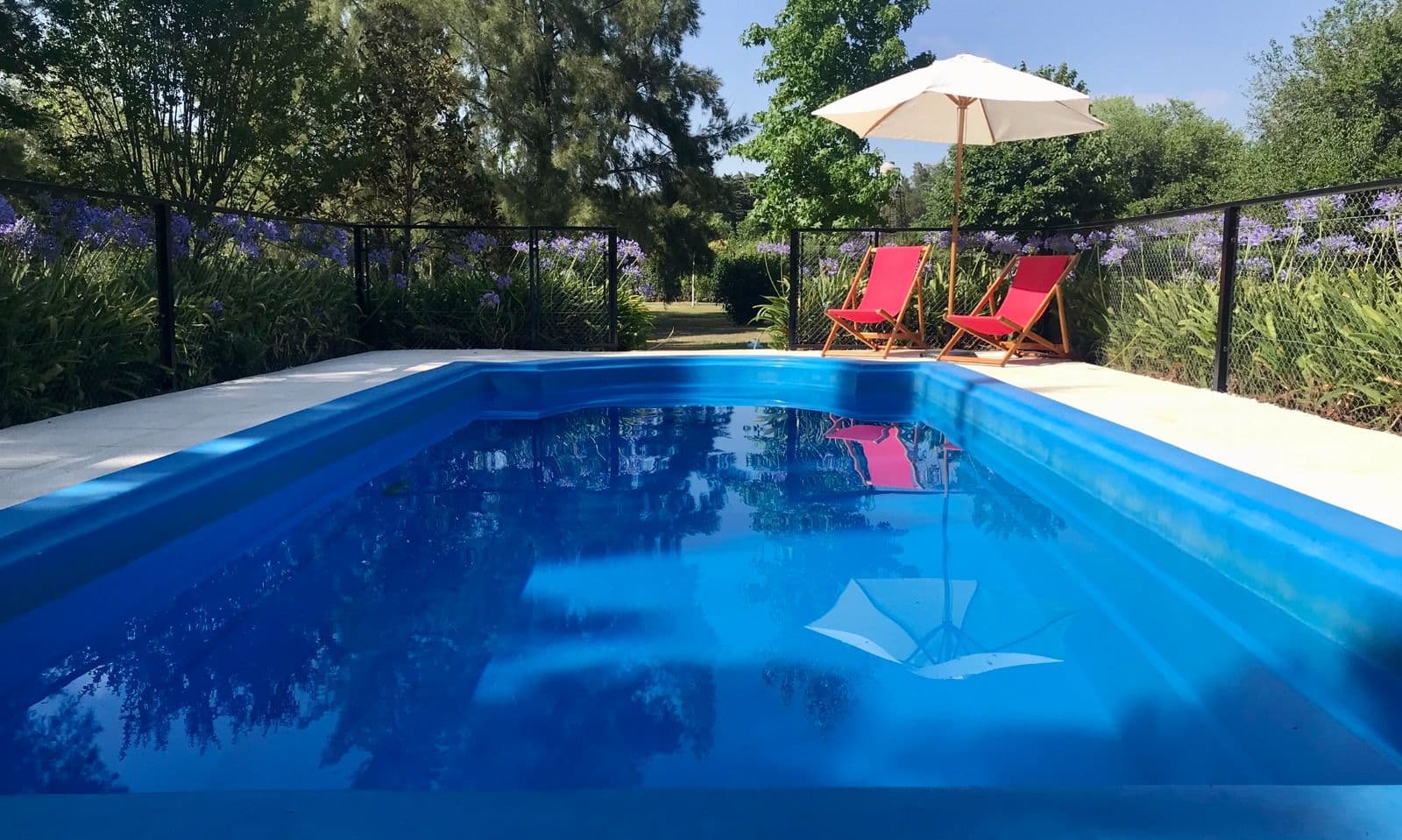 Piscina de La Calandria Casa de Campo con reposeras y jardín